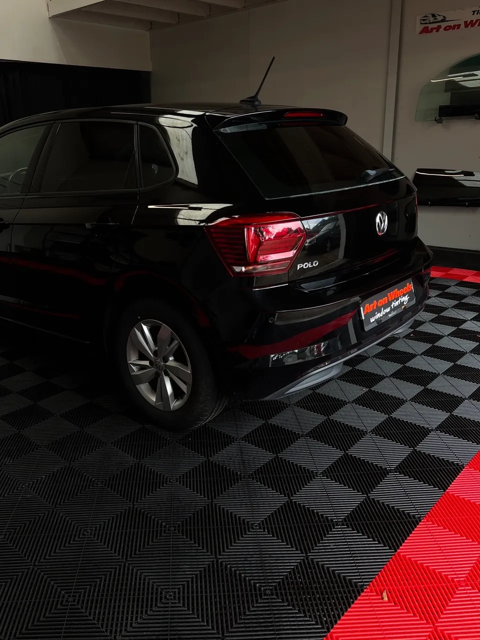 Zwarte Volkswagen Polo met getinte ruiten in de showroom